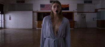 Movie still from “Chambers” (2019), created by Leah Rachel – A woman in a blue robe standing in front of a us flag; Medium shot, Low angle