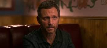 Movie still from “Chambers” (2019), created by Leah Rachel – A person sitting on a couch; Close Up shot, Over the shoulder angle