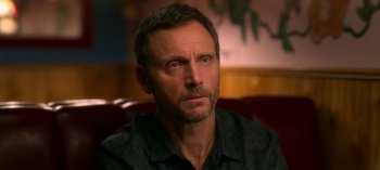 Movie still from “Chambers” (2019), created by Leah Rachel – A person sitting on a couch; Close Up shot, Over the shoulder angle