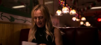 Movie still from “Chambers” (2019), created by Leah Rachel – A woman sitting at a table looking down at a piece of paper; Close Up shot, Over the shoulder angle