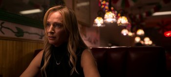 Movie still from “Chambers” (2019), created by Leah Rachel – A woman sitting in front of a bunch of christmas lights; Close Up shot, Over the shoulder angle