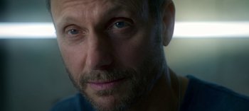 Movie still from “Chambers” (2019), created by Leah Rachel – A man with a beard looking at the camera; Extreme Close Up shot, Over the shoulder angle