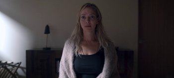 Movie still from “Chambers” (2019), created by Leah Rachel – A woman in a black shirt and a white sweater; Close Up shot, Low angle