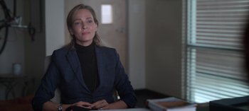 Movie still from “Chambers” (2019), created by Leah Rachel – A woman sitting at a table in front of a window; Close Up shot, Over the shoulder angle