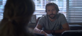 Movie still from “Chambers” (2019), created by Leah Rachel – A man sitting in front of a woman in front of a window; Close Up shot, Over the shoulder angle