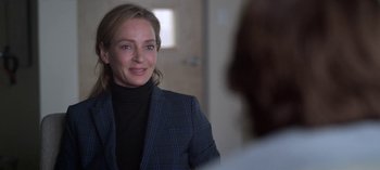 Movie still from “Chambers” (2019), created by Leah Rachel – A woman wearing a suit and smiling for the camera; Close Up shot, Over the shoulder angle