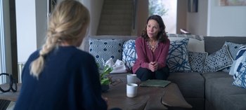 Movie still from “Chambers” (2019), created by Leah Rachel – A woman sitting on top of a couch talking to another woman; Medium shot, Over the shoulder angle