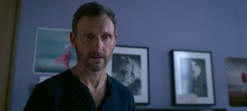 Movie still from “Chambers” (2019), created by Leah Rachel – A person wearing a black shirt; Close Up shot, Over the shoulder angle