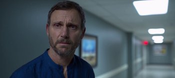 Movie still from “Chambers” (2019), created by Leah Rachel – A person in a room near a wall; Close Up shot, Over the shoulder angle