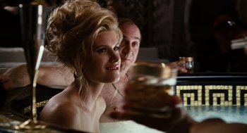 Movie still from “Charlie Wilson's War” (2007), directed by Mike Nichols – A beautiful woman with long blonde hair sitting next to a man; Close Up shot, Over the shoulder angle