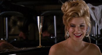 Movie still from “Charlie Wilson's War” (2007), directed by Mike Nichols – A beautiful woman with blonde hair sitting next to a glass of champagne; Close Up shot, Over the shoulder angle