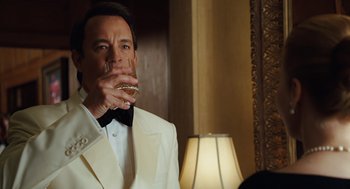 Movie still from “Charlie Wilson's War” (2007), directed by Mike Nichols – A man in a white tuxedo drinking a glass of wine; Close Up shot, Over the shoulder angle