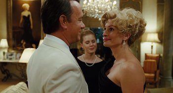 Movie still from “Charlie Wilson's War” (2007), directed by Mike Nichols – A man and a woman standing next to each other in front of another woman; Close Up shot, Over the shoulder angle
