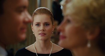 Movie still from “Charlie Wilson's War” (2007), directed by Mike Nichols – A woman in a black dress and a pearl necklace; Close Up shot, Over the shoulder angle