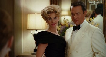 Movie still from “Charlie Wilson's War” (2007), directed by Mike Nichols – A man and a woman dressed up in formal wear; Medium shot, Low angle