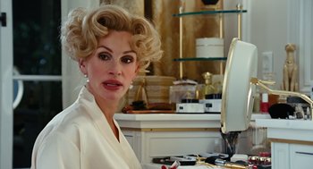 Movie still from “Charlie Wilson's War” (2007), directed by Mike Nichols – A woman in a white bathrobe in front of a mirror; Close Up shot, Over the shoulder angle