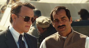 Movie still from “Charlie Wilson's War” (2007), directed by Mike Nichols – A man and a man in a suit and tie standing next to each other; Close Up shot, Over the shoulder angle