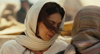 Movie still from “Charlie Wilson's War” (2007), directed by Mike Nichols – A woman wearing a head scarf and a white shirt; Close Up shot, Over the shoulder angle