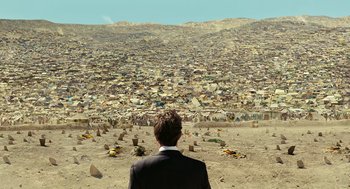 Movie still from “Charlie Wilson's War” (2007), directed by Mike Nichols – A man standing in front of a large amount of garbage; Extreme Wide shot, High angle