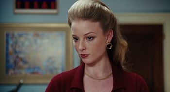 Movie still from “Charlie Wilson's War” (2007), directed by Mike Nichols – A woman in a red shirt and a gold necklace; Close Up shot, Over the shoulder angle