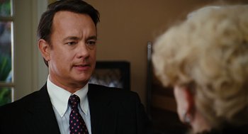 Movie still from “Charlie Wilson's War” (2007), directed by Mike Nichols – A man wearing a suit and tie talking to a woman; Close Up shot, Over the shoulder angle
