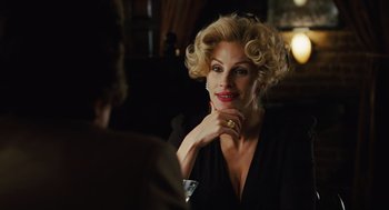 Movie still from “Charlie Wilson's War” (2007), directed by Mike Nichols – A woman sitting in front of a man in a black shirt; Close Up shot, Over the shoulder angle