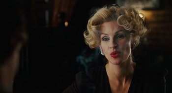 Movie still from “Charlie Wilson's War” (2007), directed by Mike Nichols – A beautiful woman with blonde curly hair and red lipstick; Close Up shot, Low angle
