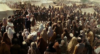 Movie still from “Charlie Wilson's War” (2007), directed by Mike Nichols – A large group of people gathered together in a field; Wide shot, High angle