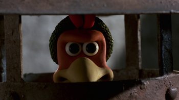 Movie still from “Chicken Run” (2000), directed by Peter Lord – The head of a toy chicken; Close Up shot, High angle