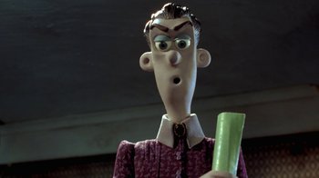 Movie still from “Chicken Run” (2000), directed by Peter Lord – A cartoon character holding a green object; Close Up shot, Over the shoulder angle