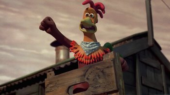 Movie still from “Chicken Run” (2000), directed by Peter Lord – A cartoon chicken is standing in front of a wooden box; Medium shot, Low angle