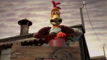 Movie still from “Chicken Run” (2000), directed by Peter Lord – A statue of a chicken is shown in front of a sky background; Medium shot, Low angle