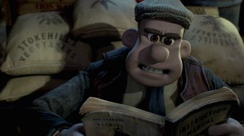 Movie still from “Chicken Run” (2000), directed by Peter Lord – A man reading a book while sitting on a couch; Close Up shot, High angle