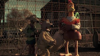 Movie still from “Chicken Run” (2000), directed by Peter Lord – A group of stuffed animals standing next to each other near a chicken coop; Medium shot, Low angle