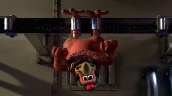 Movie still from “Chicken Run” (2000), directed by Peter Lord – A turkey head hanging from the side of a wall; Medium shot, Overhead angle