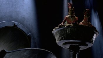 Movie still from “Chicken Run” (2000), directed by Peter Lord – A statue sitting on top of a sink; Wide shot, Low angle