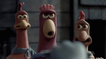 Movie still from “Chicken Run” (2000), directed by Peter Lord – A toy chicken with other toy chickens in the background; Close Up shot, High angle