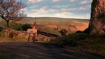Movie still from “Chicken Run” (2000), directed by Peter Lord – An animal sitting on top of a cart on the side of a road; Extreme Wide shot, High angle