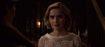 Movie still from “Chilling Adventures of Sabrina” (2018), created by Roberto Aguirre-Sacasa – A person with short hair; Close Up shot, Over the shoulder angle