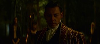 Movie still from “Chilling Adventures of Sabrina” (2018), created by Roberto Aguirre-Sacasa – A person wearing a suit and tie; Close Up shot, Over the shoulder angle