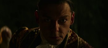 Movie still from “Chilling Adventures of Sabrina” (2018), created by Roberto Aguirre-Sacasa – A person wearing a suit; Close Up shot, Low angle