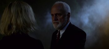 Movie still from “Chilling Adventures of Sabrina” (2018), created by Roberto Aguirre-Sacasa – An older man in a suit and a red neck tie; Close Up shot, Over the shoulder angle