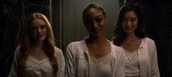 A group of women standing next to each other in a room