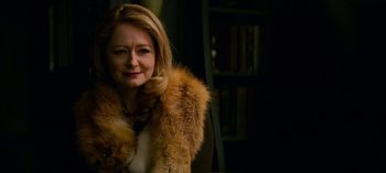 Movie still from “Chilling Adventures of Sabrina” (2018), created by Roberto Aguirre-Sacasa – A woman wearing a fur coat in front of a book case; Close Up shot, Over the shoulder angle