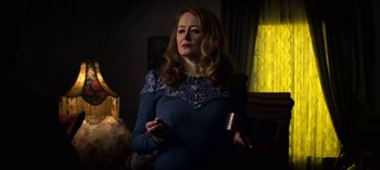 Movie still from “Chilling Adventures of Sabrina” (2018), created by Roberto Aguirre-Sacasa – A woman holding a cell phone in her hand; Medium shot, Low angle