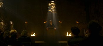 Movie still from “Chilling Adventures of Sabrina” (2018), created by Roberto Aguirre-Sacasa – A man standing in front of a fire pit; Wide shot, Low angle