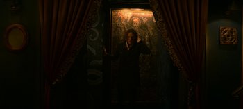 Movie still from “Chilling Adventures of Sabrina” (2018), created by Roberto Aguirre-Sacasa – A woman standing in a doorway with a painting on the wall; Wide shot, Low angle