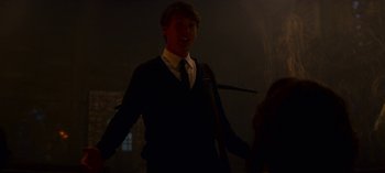 Movie still from “Chilling Adventures of Sabrina” (2018), created by Roberto Aguirre-Sacasa – A man in a suit and tie holding a cane in a dark room; Medium shot, Over the shoulder angle