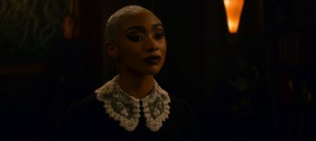 Movie still from “Chilling Adventures of Sabrina” (2018), created by Roberto Aguirre-Sacasa – A woman with a bald head wearing a black shirt; Close Up shot, Over the shoulder angle