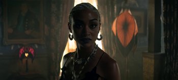 Movie still from “Chilling Adventures of Sabrina” (2018), created by Roberto Aguirre-Sacasa – A woman in a black dress and a necklace; Close Up shot, Over the shoulder angle